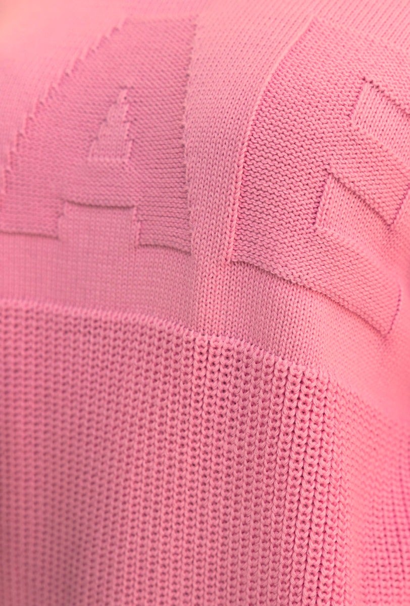Close-up of Raymer Jumper in pink, featuring embossed 'AAE' design and textured knit material.