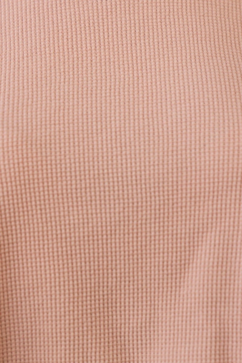 Close-up of textured pink cotton fabric, showcasing the intricate weave of the Tyrra Top, ideal for a relaxed crop fit.