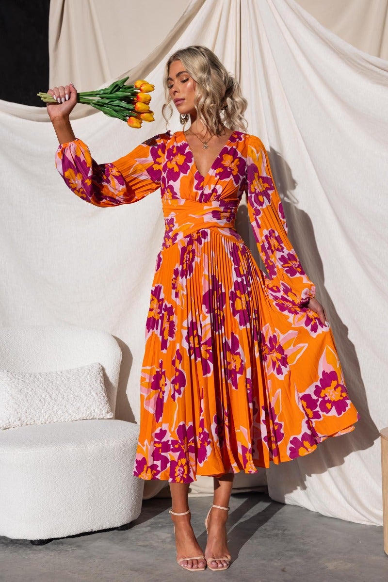 Normia Midi Dress in floral print, featuring a V-neckline and pleat material, styled with a bouquet of tulips.