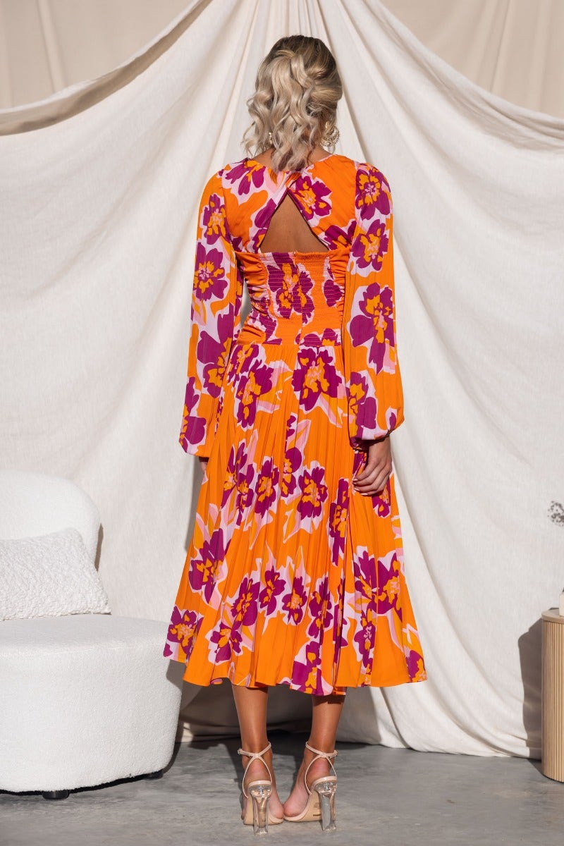 Back view of Normia Midi Dress, featuring floral print, cut-out detail, and pleated skirt.