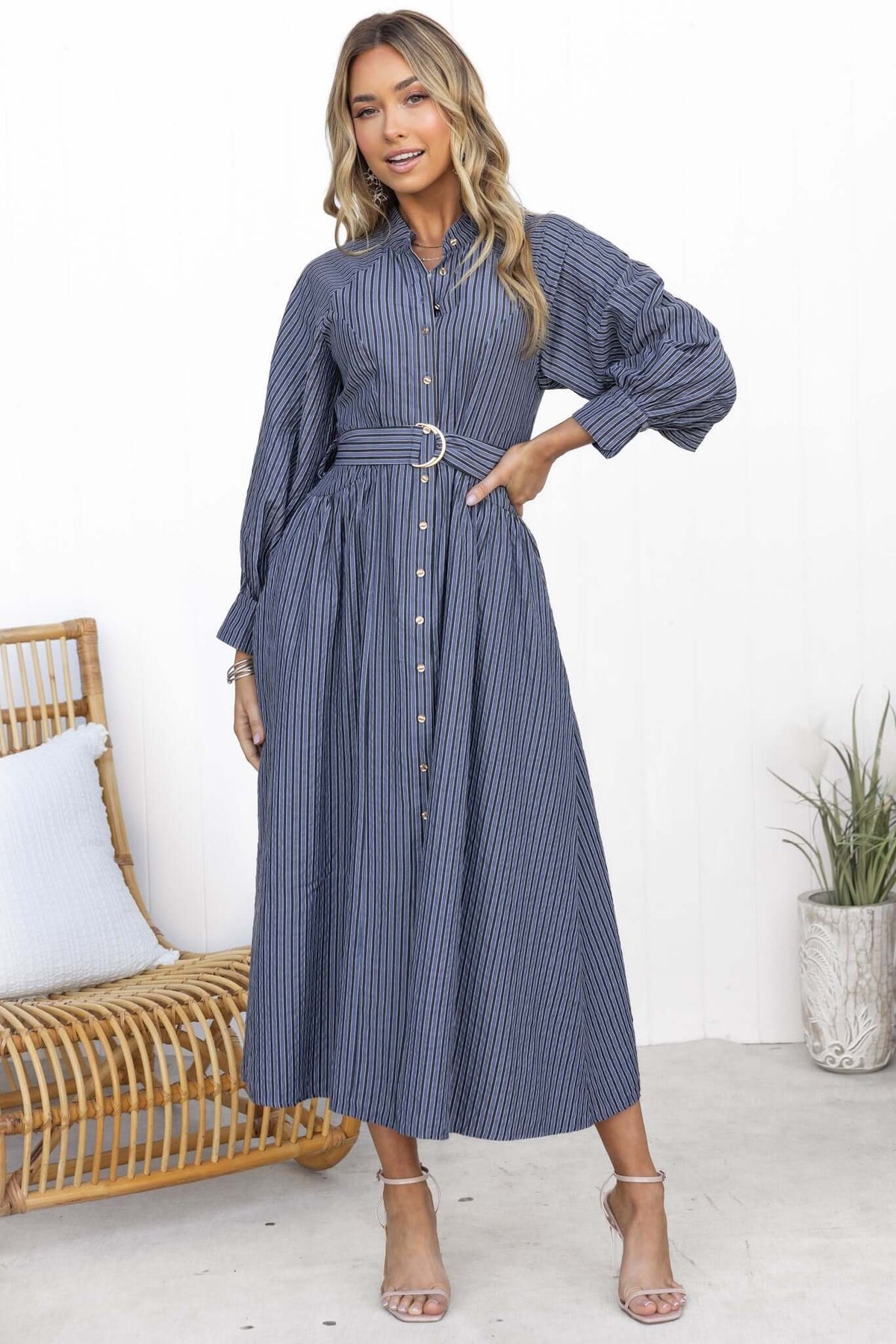 Woman in a blue striped Greyer maxi dress with button-up front, elastic sleeves, and removable belt.