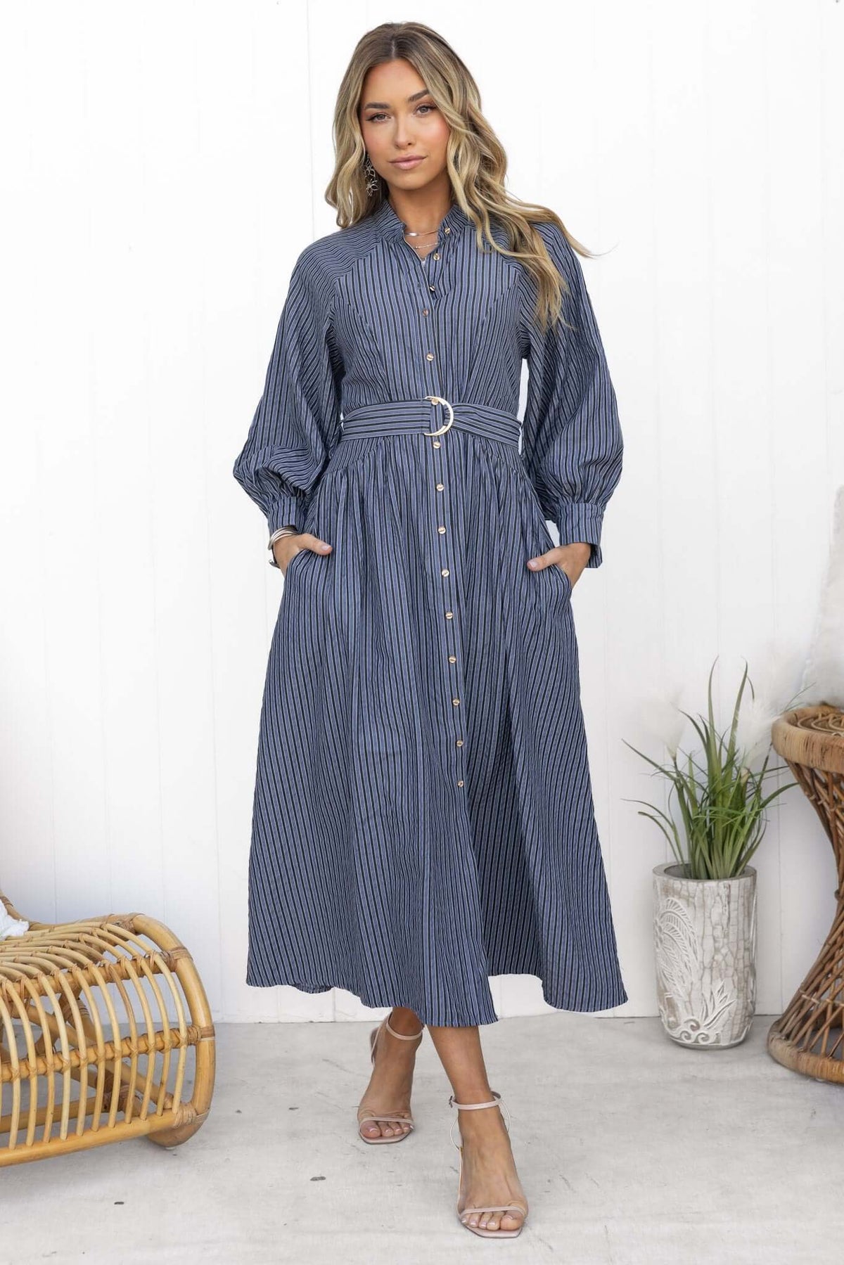 Model wearing a Greyer Maxi Dress, featuring a button-up front, elastic sleeves, and removable belt, set against a neutral backdrop.