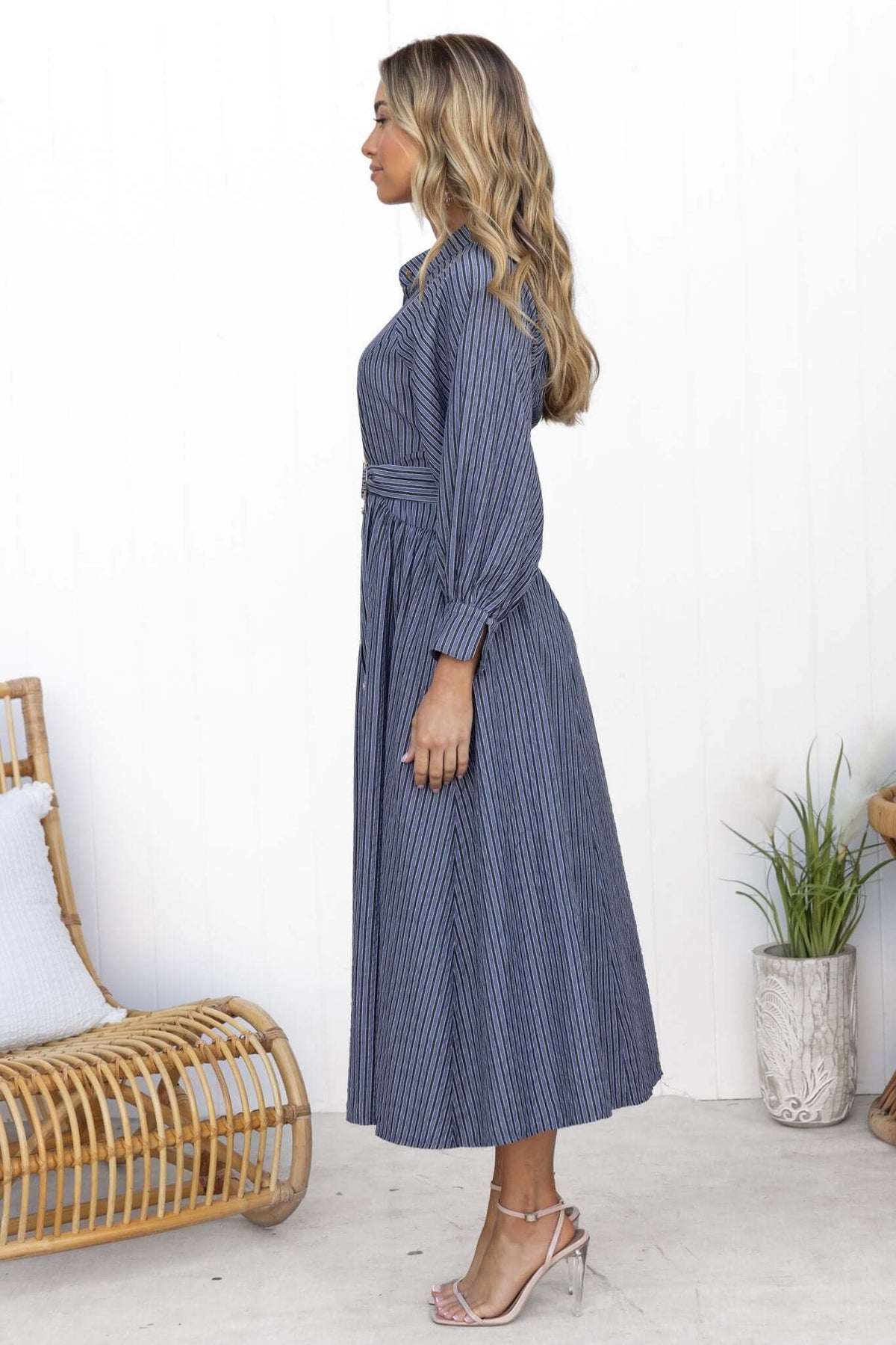 Side view of a woman wearing a Greyer Maxi Dress with button-up front, elastic sleeves, and a removable belt.