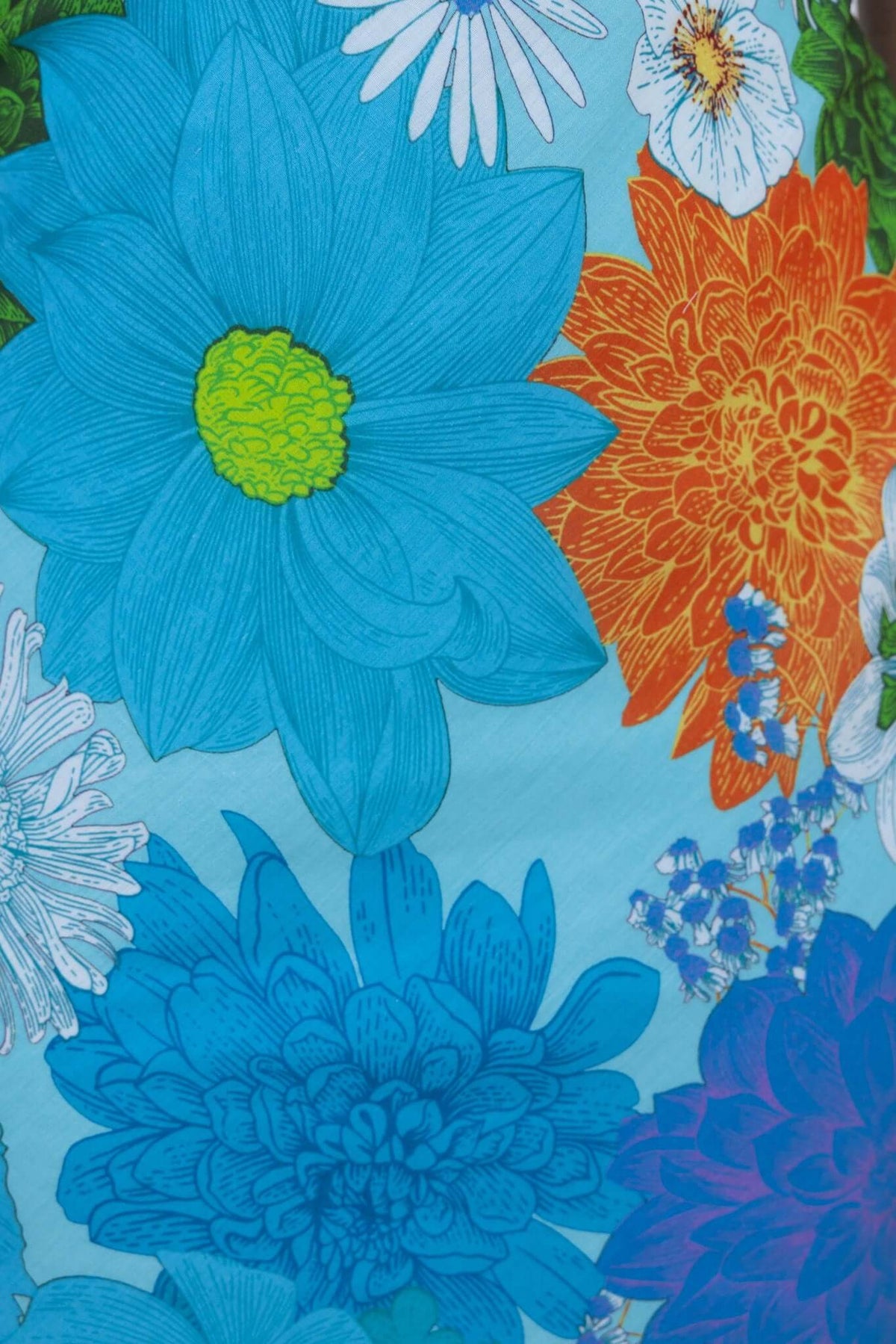 Close-up of colorful floral print featuring blue and orange flowers on a bright background, ideal for a summer maxi dress.