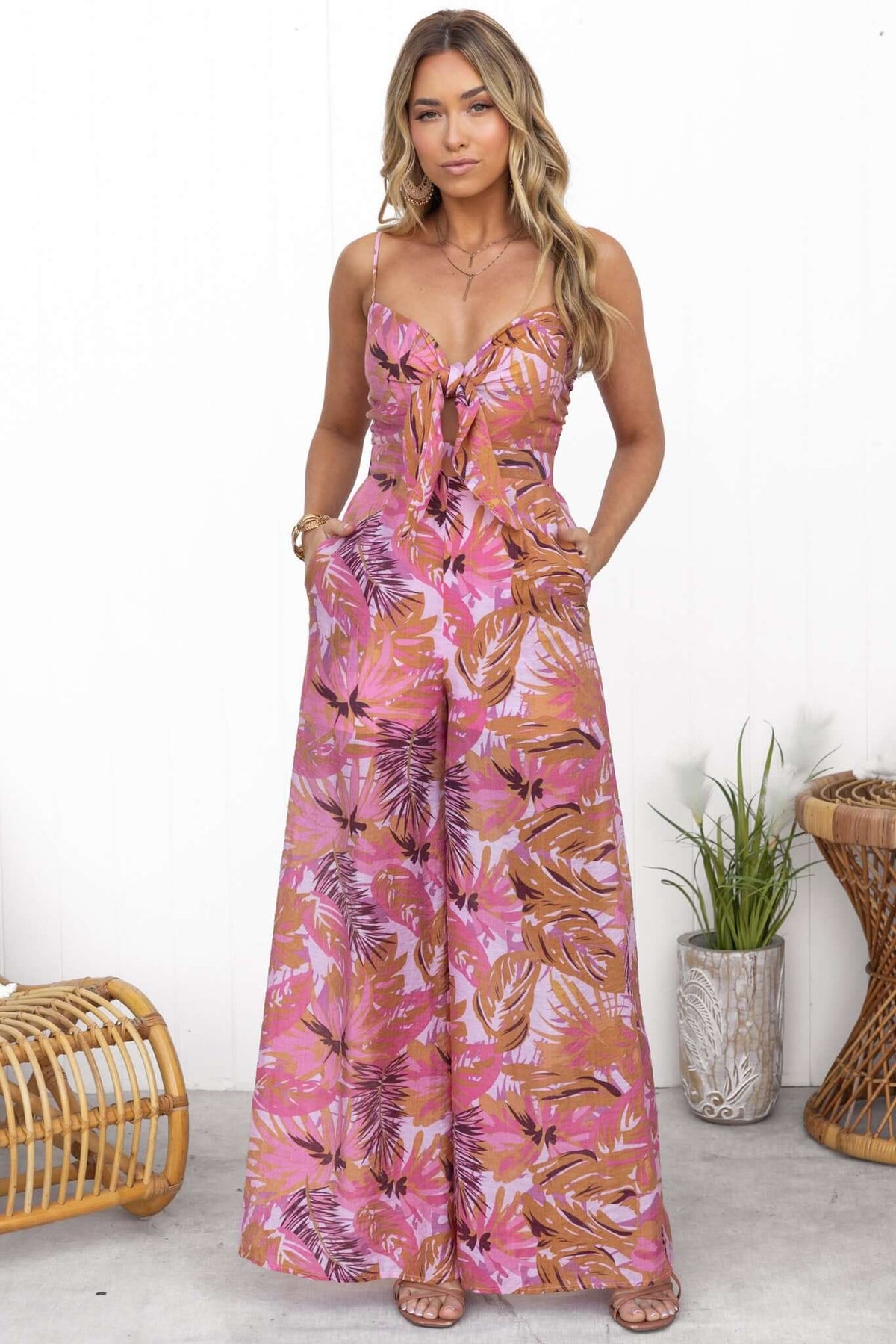 Sun Dazed Jumpsuit featuring a multi-colour floral print, adjustable straps, tie bust, and pockets, styled for a standard fit.