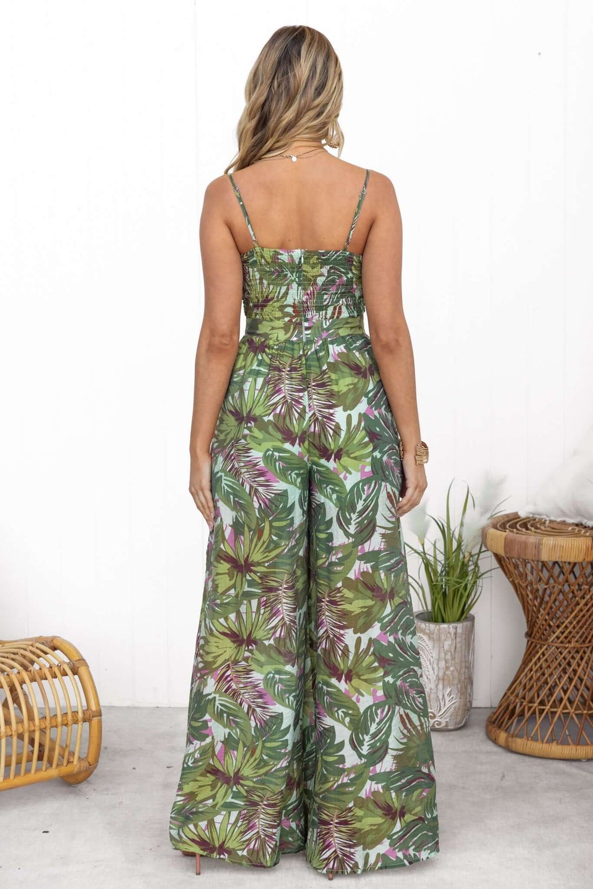 Back view of Sun Dazed Jumpsuit featuring multi-colour tropical print, adjustable straps, and a tie at the bust.