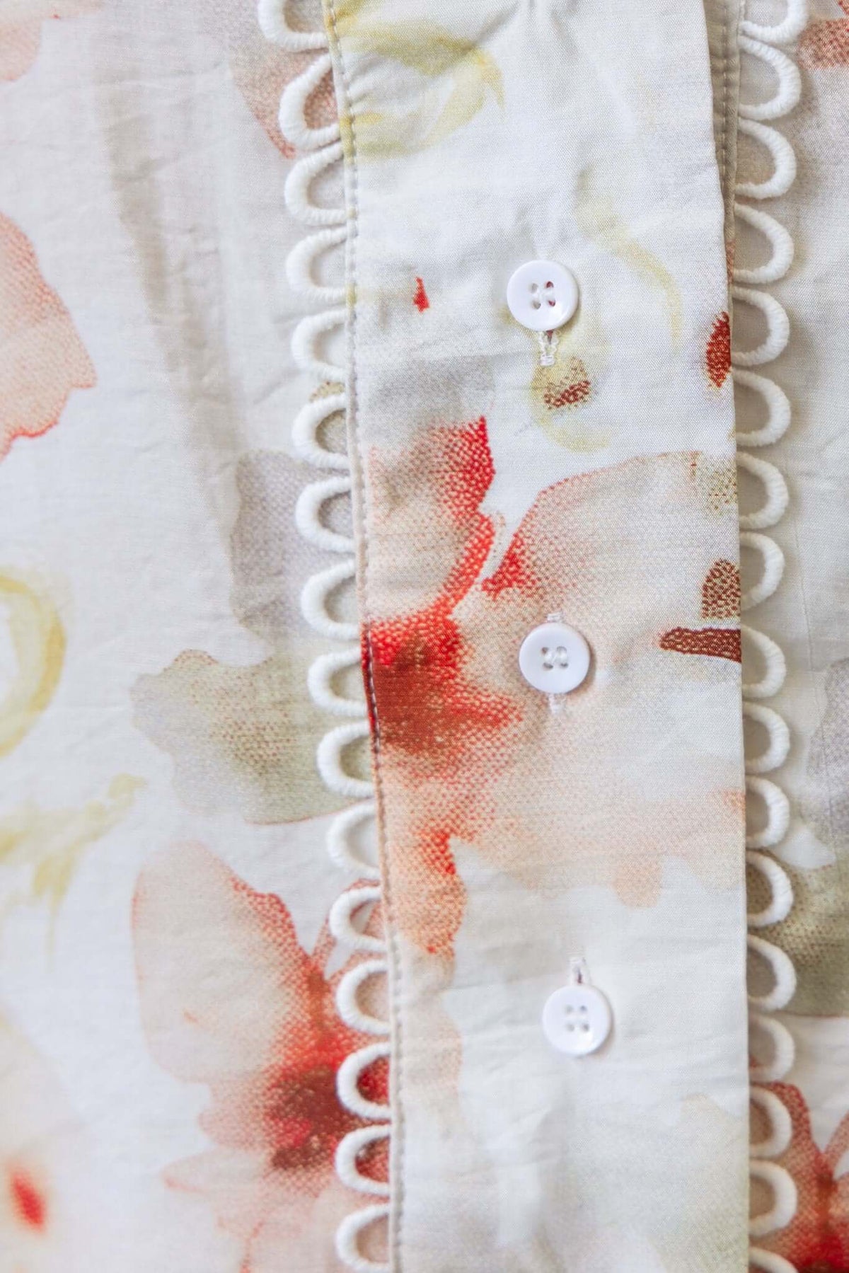 Close-up of Kellee Shirt featuring floral print, button-up front, and elegant scalloped trim detail.