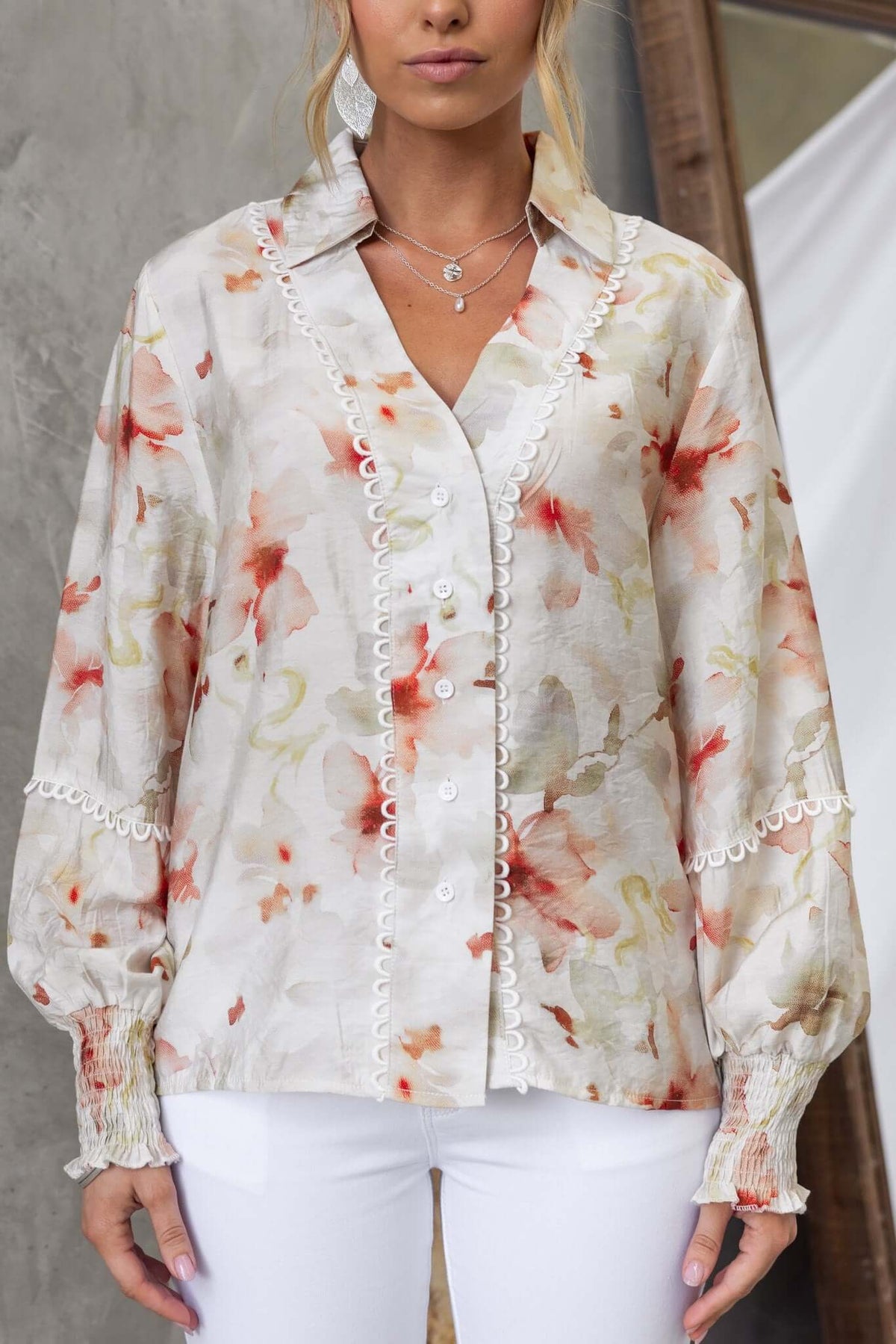 Kellee Shirt featuring floral design, button-up front, and elastic sleeves, styled with white pants.
