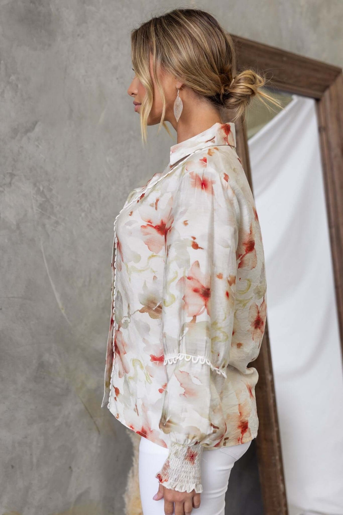 Side view of Kellee shirt featuring floral pattern, button-up front, and elastic sleeves worn by a model.