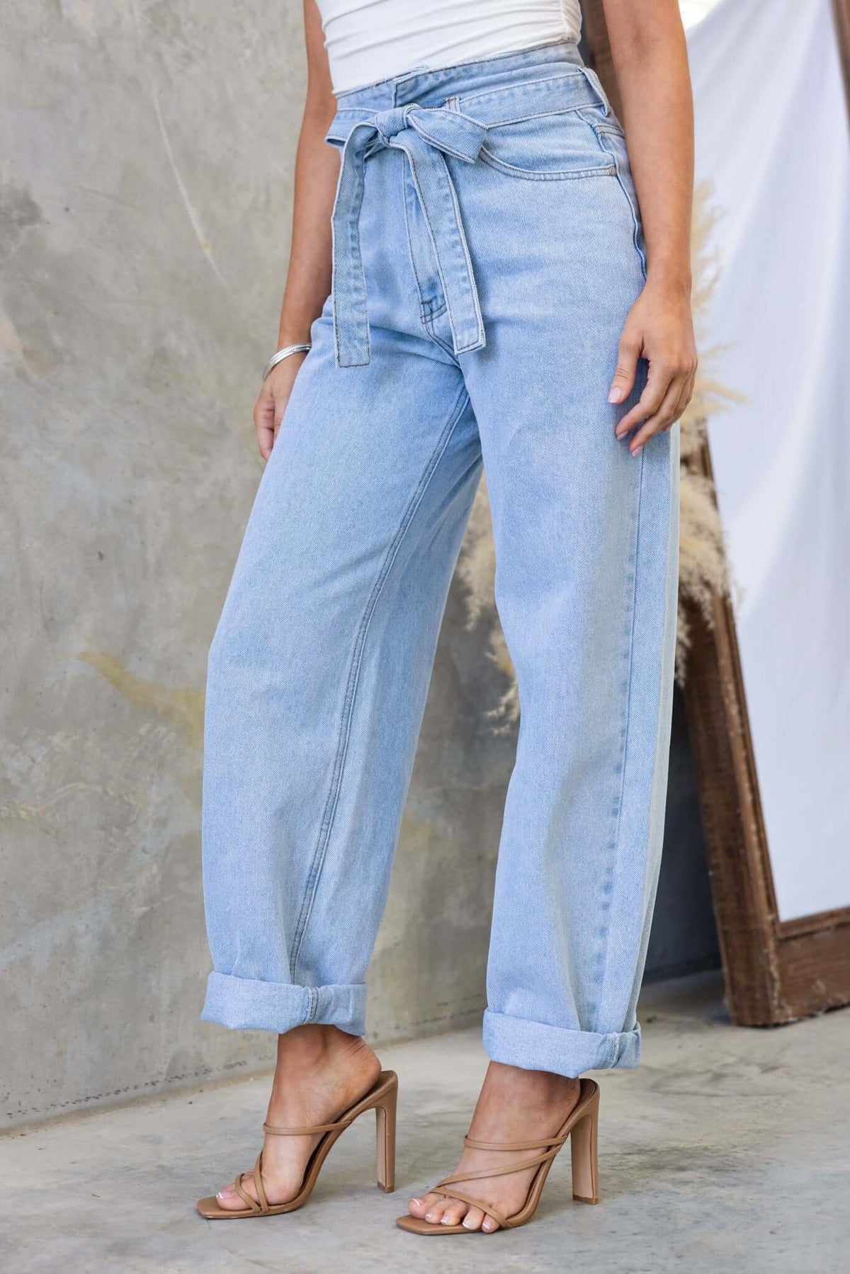 Henderson Jeans in light blue with a mid-high waist, paper-bag style, and removable belt, showcased by a model.