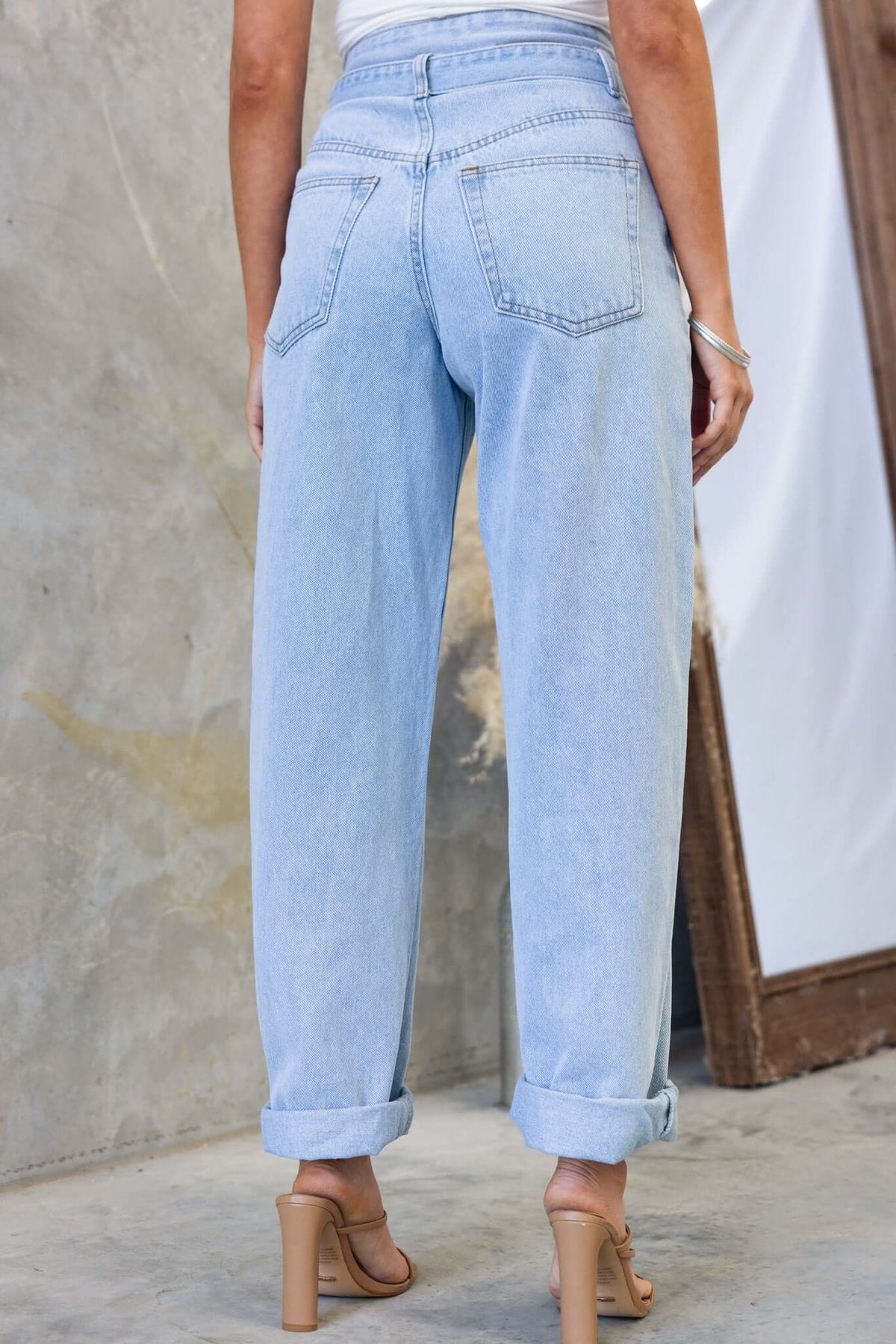 Back view of Henderson jeans featuring a mid-high waist and rolled cuffs, shown in light wash denim.