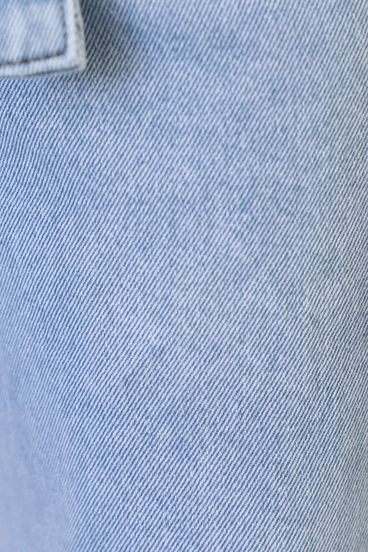 Close-up of Henderson Jeans denim fabric, showcasing its light blue color and texture.