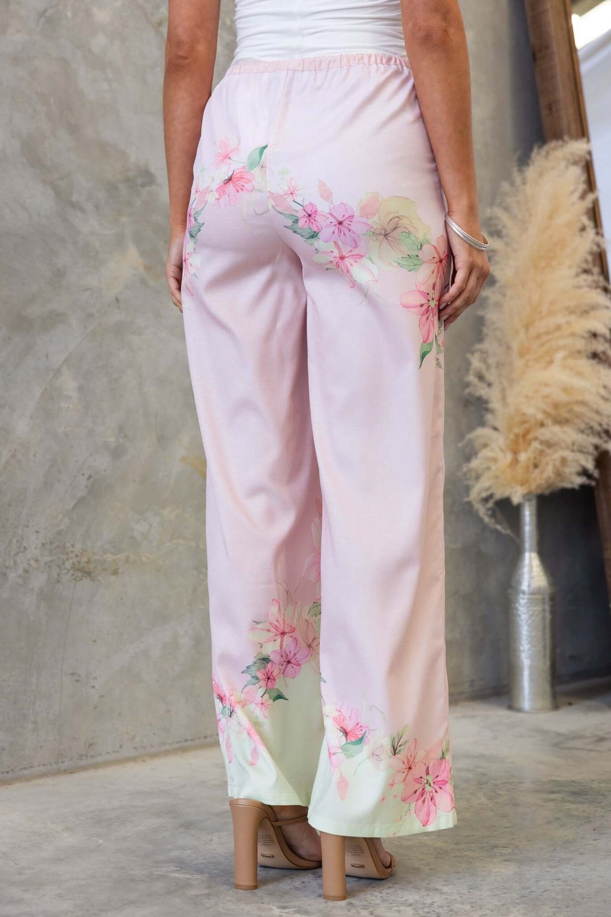 Back view of Avalon Pants in pink with floral design, mid-high waist, and elastic waistband.
