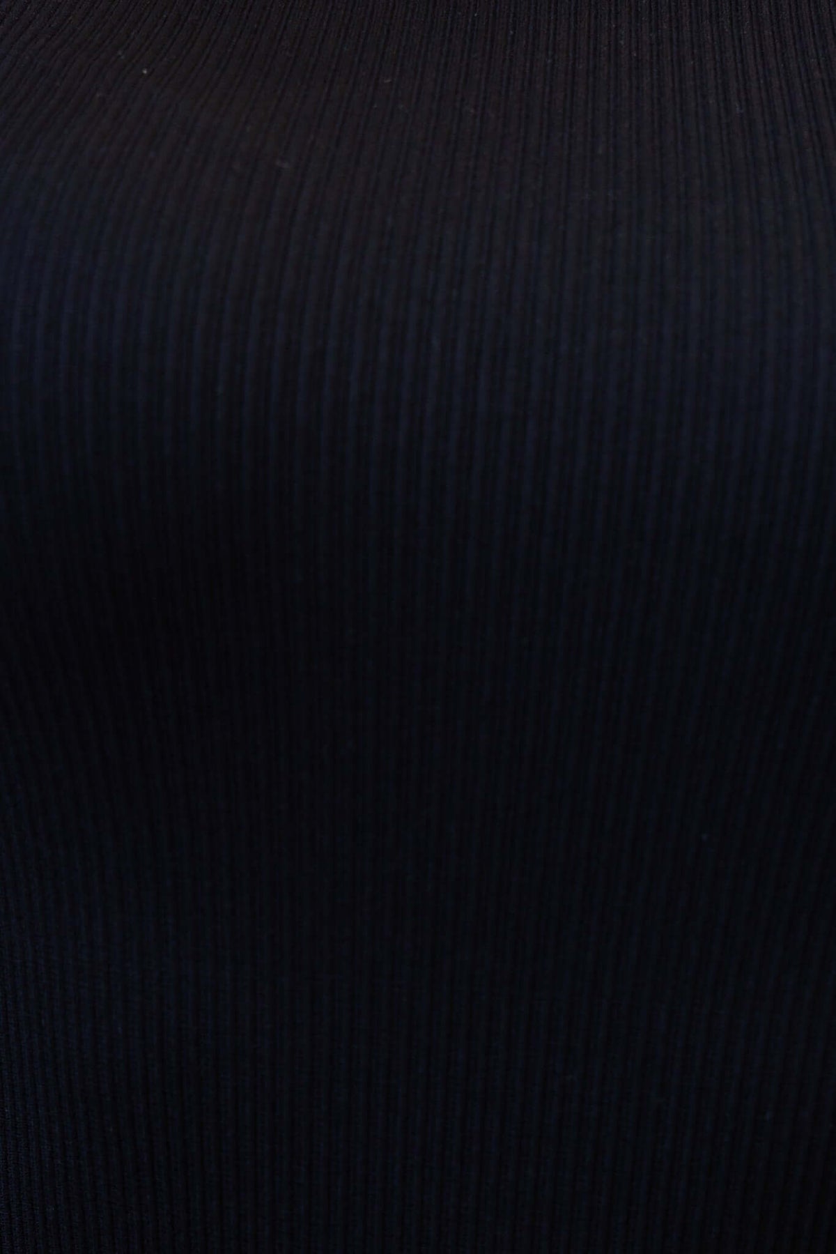 Close-up of black ribbed fabric of the Ruston Bodysuit showcasing its texture and stretchy material.