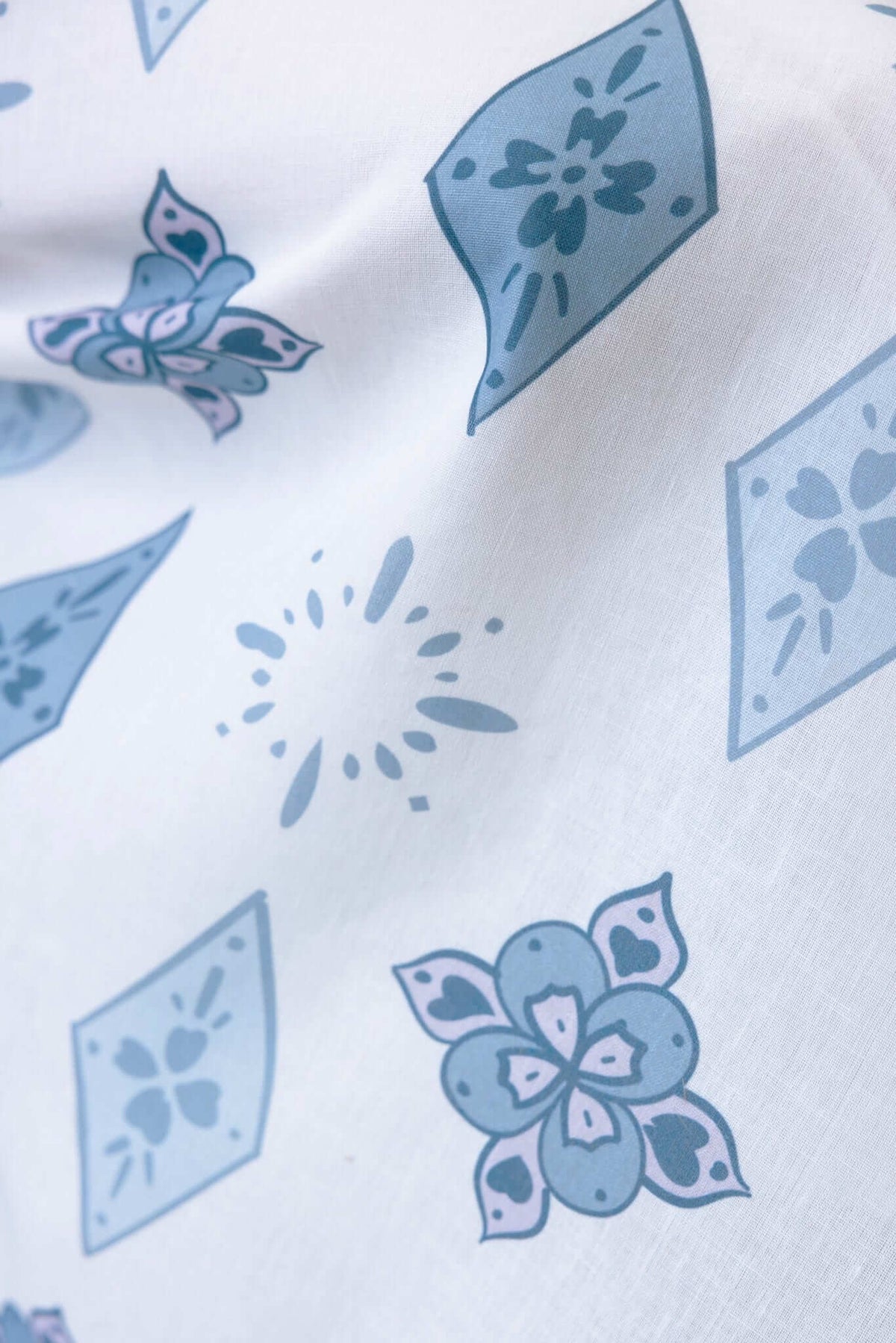 Close-up of a floral patterned fabric with blue and white designs on a light background.