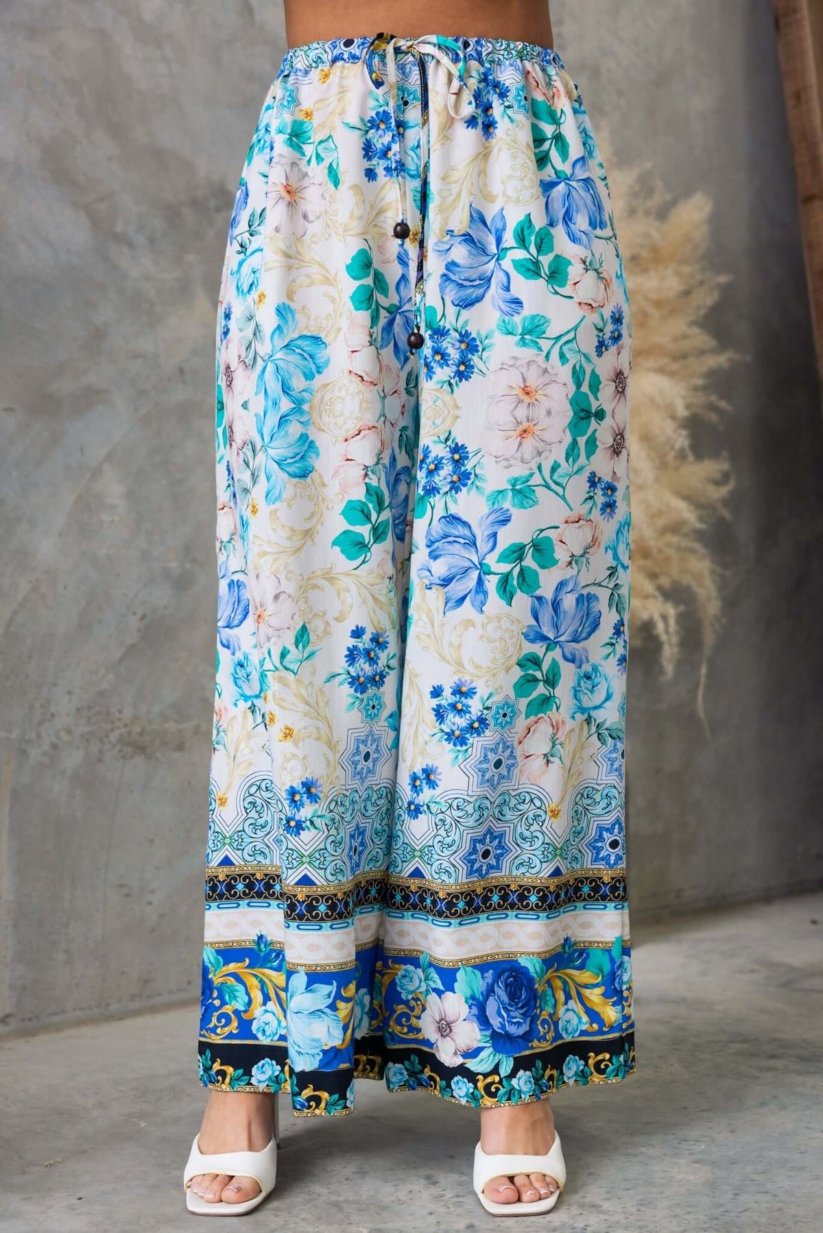 Valora Pants: Floral mid-high waist pants with drawstring and pockets, featuring a vibrant blue and white design.
