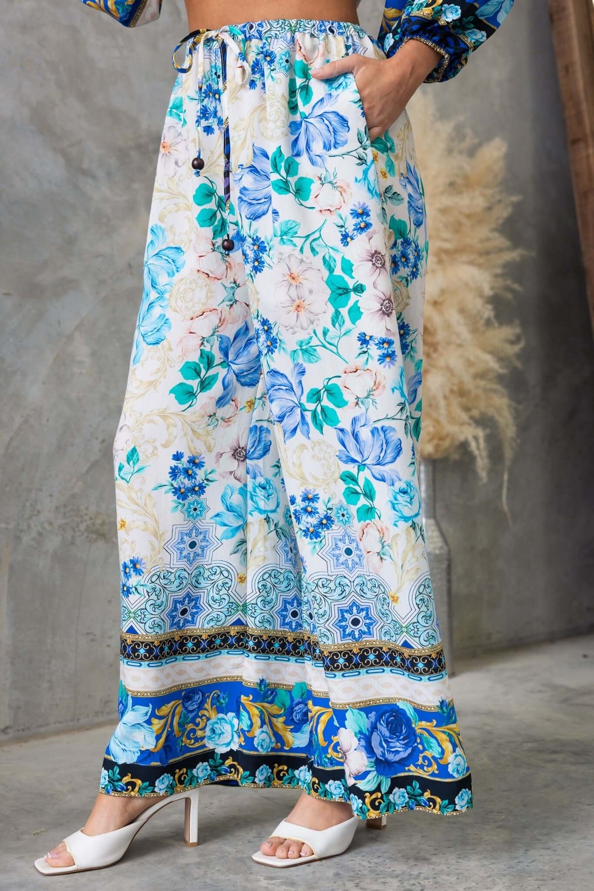 Valora Pants with floral print, elastic waistband, drawstring, and pockets, styled for a casual summer look.