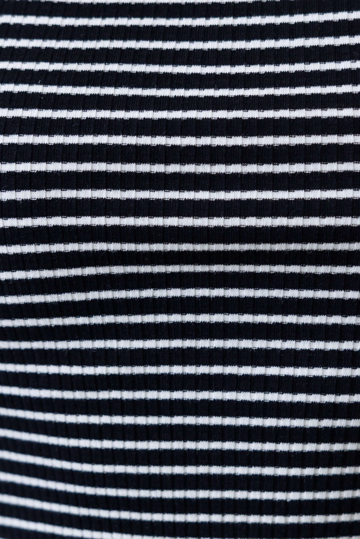 Close-up of black and white striped ribbed knit fabric of the Lecco Top, showcasing its texture and stretch.