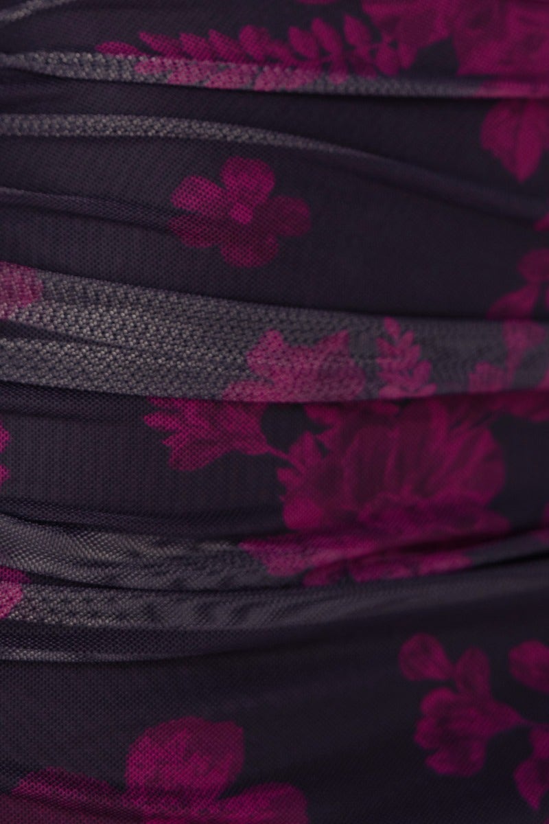 Close-up of textured floral mesh fabric with deep purple flowers on a black background for the Espia Midi Dress.