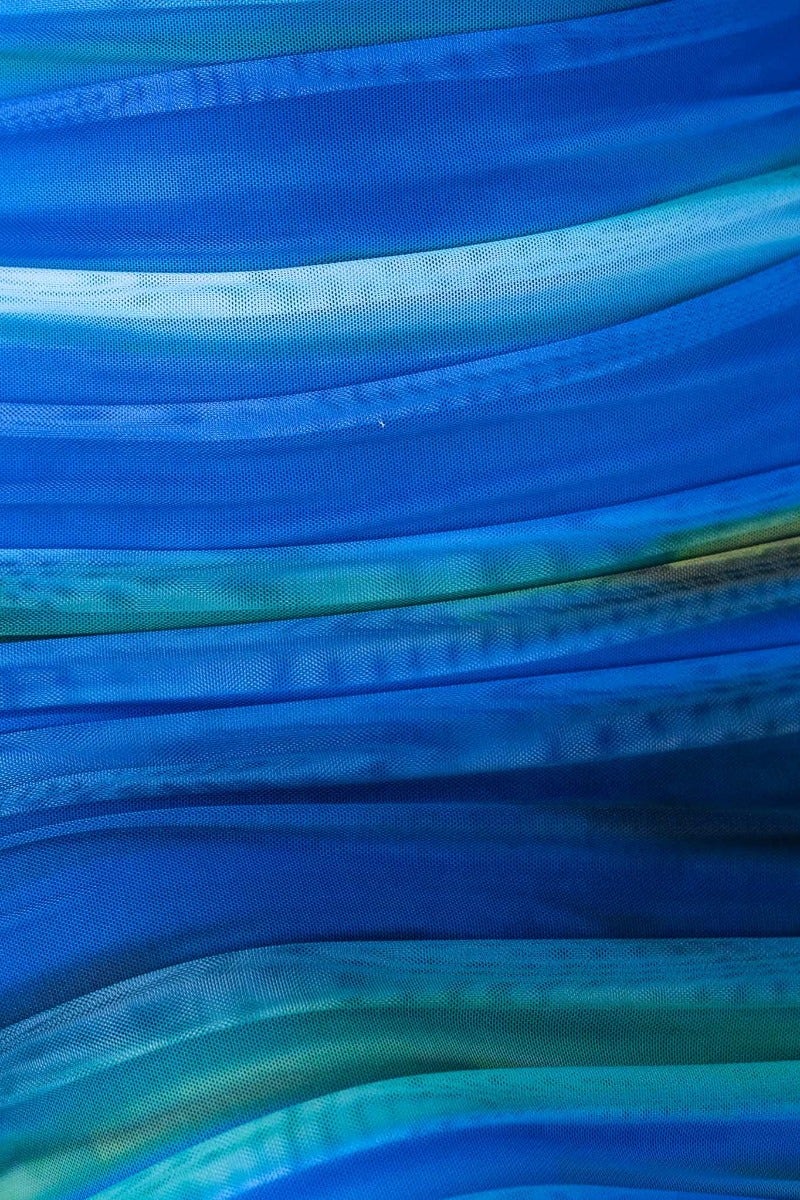 Blue and green flowing fabric with wavy textures, showcasing a mesh overlay design suitable for stylish clothing.