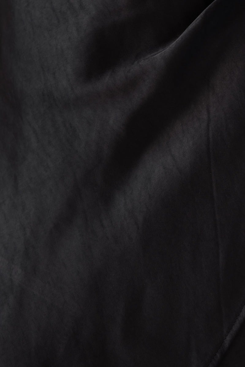 Close-up of the silky black fabric texture of the Angels Like You Dress, showcasing its smooth feel and elegant look.