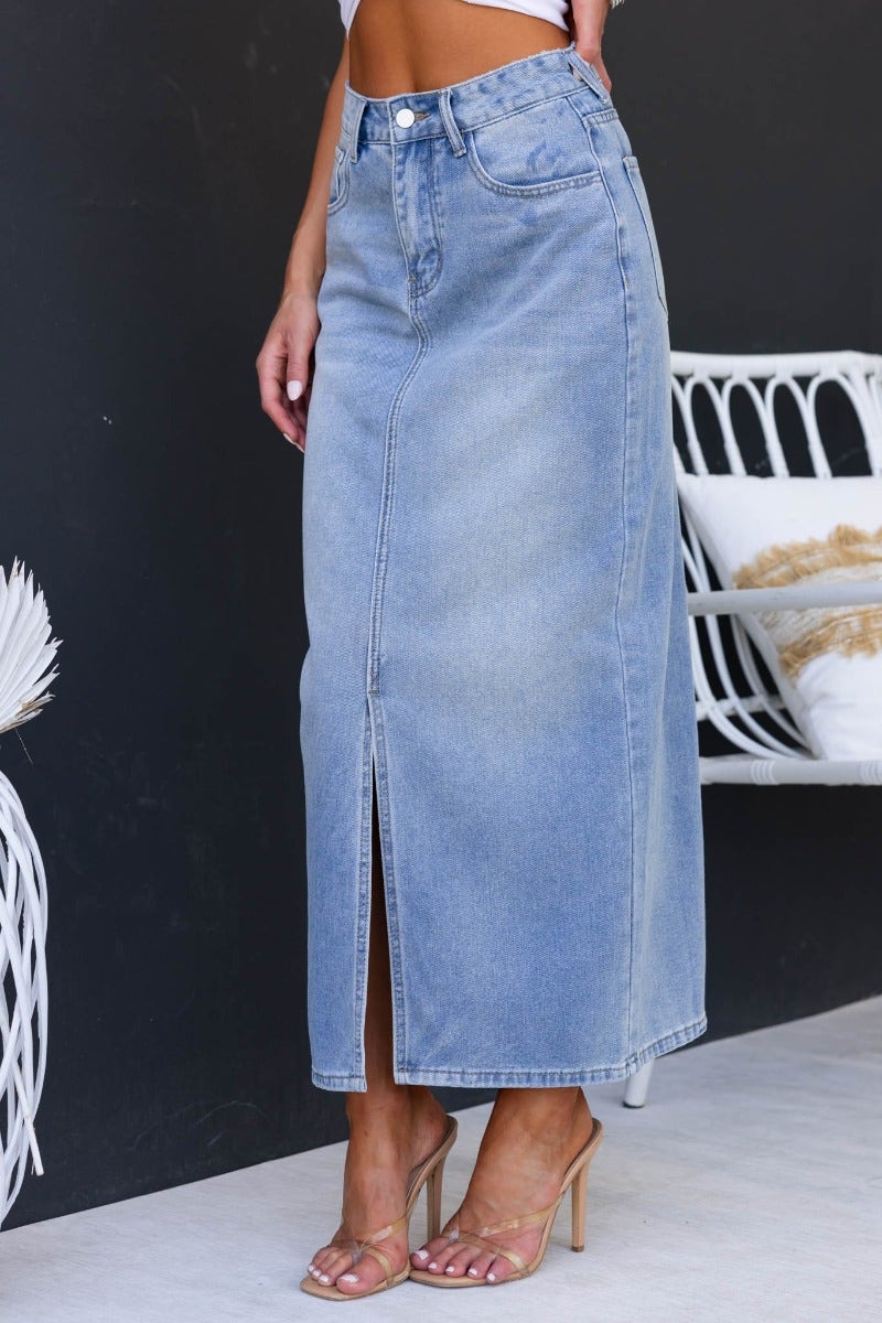 Light blue denim maxi skirt with front split and mid-high waist, styled with a casual outfit.