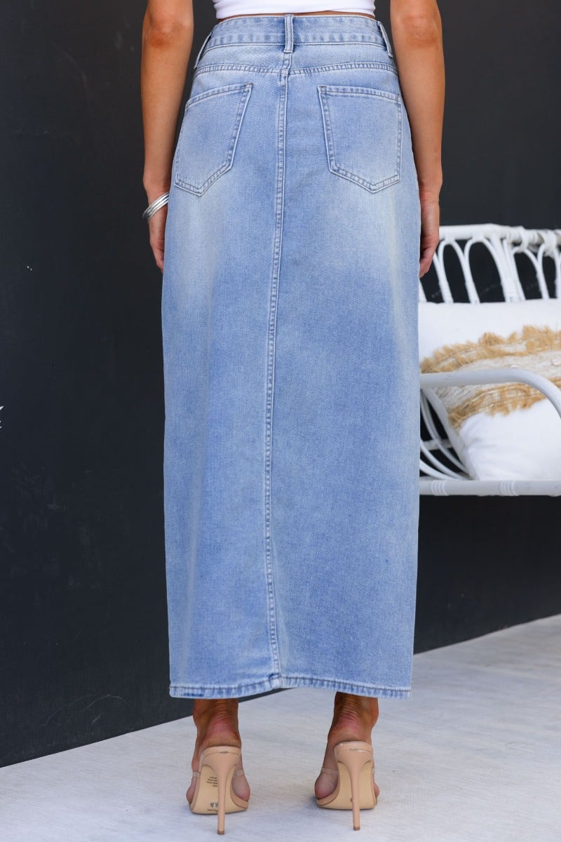 Back view of Carlow Denim Maxi Skirt, showcasing a light blue, mid-high waist fit with pockets and a stylish split at the front.
