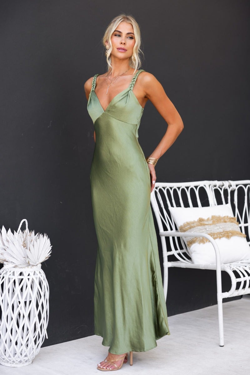 Model wearing a sleek Forest Maxi Dress in green, featuring adjustable straps and a satin finish.