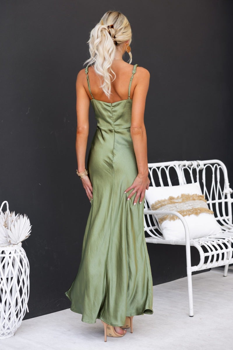 Model wearing a back view of a satin green Forest Maxi Dress featuring adjustable straps and a sleek silhouette.