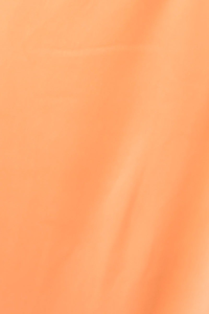 Close-up of soft peach fabric showcasing smooth texture, perfect for a stylish maxi dress with satin look.