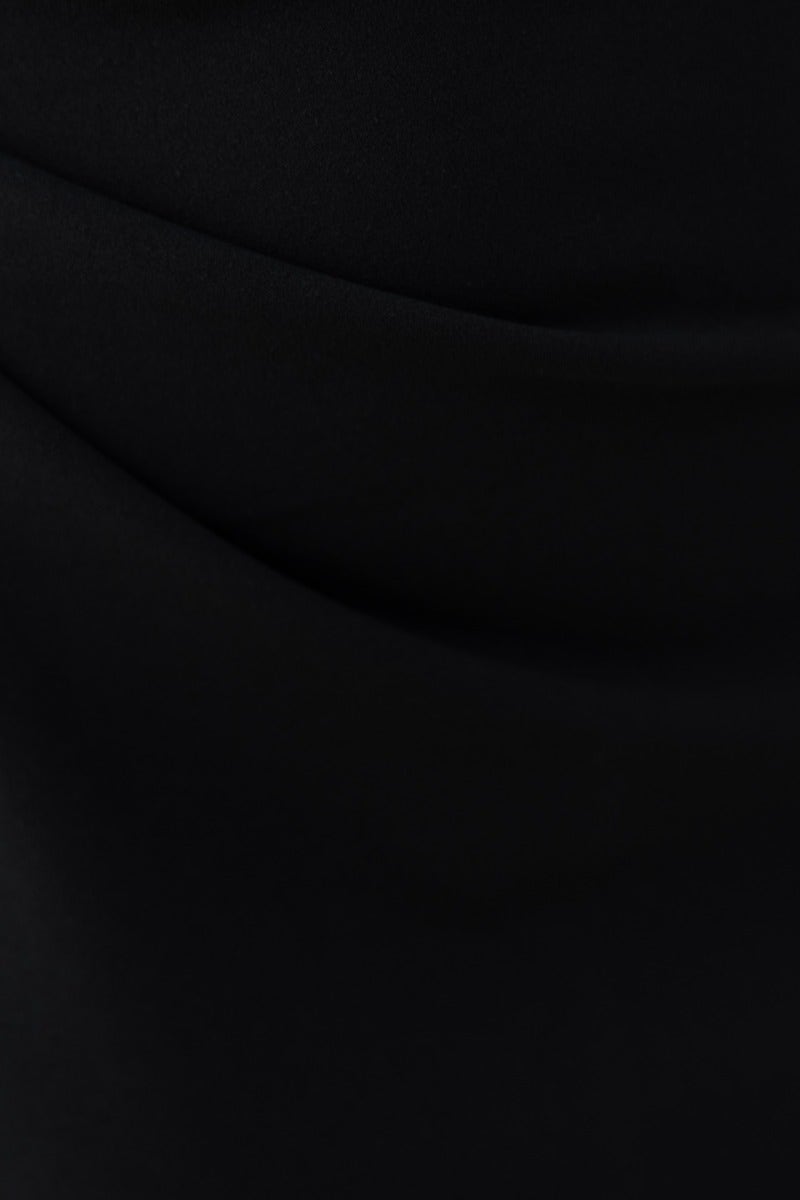 Close-up of black crepe-like fabric of the Inspired Maxi Dress, showcasing its smooth texture and sleek design.