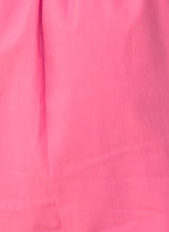 Close-up of a pink fabric, showcasing smooth texture and vibrant color ideal for summer fashion.
