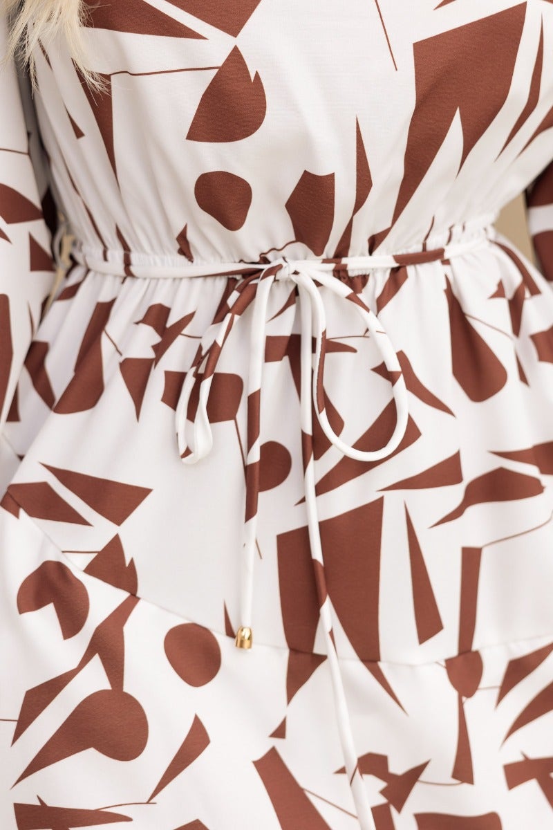 Close-up of Eleyna Dress showing adjustable fabric tie and geometric multi-color print design.