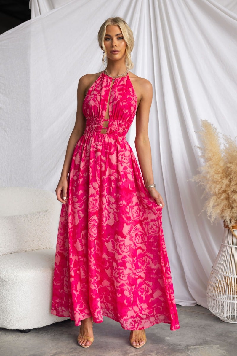 Model wearing Kariah Maxi Dress featuring a vibrant floral print, adjustable halter neckline, and elegant flowing design.