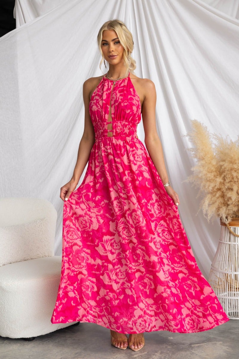 Kariah maxi dress in vibrant pink with floral print and adjustable halter neckline, perfect for summer outings.