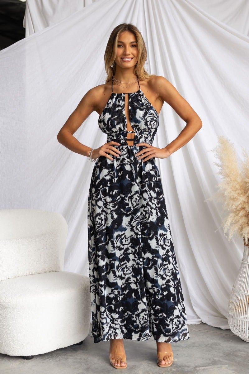 Model wearing Kariah Maxi Dress with tie halter neckline and cut-out design, showcasing elegant floral pattern.