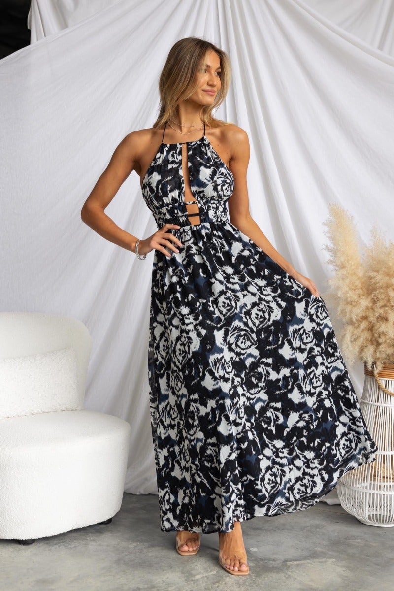 Kariah Maxi Dress featuring a black multi-colour floral design, adjustable halter neckline, and cut-outs at the bust.