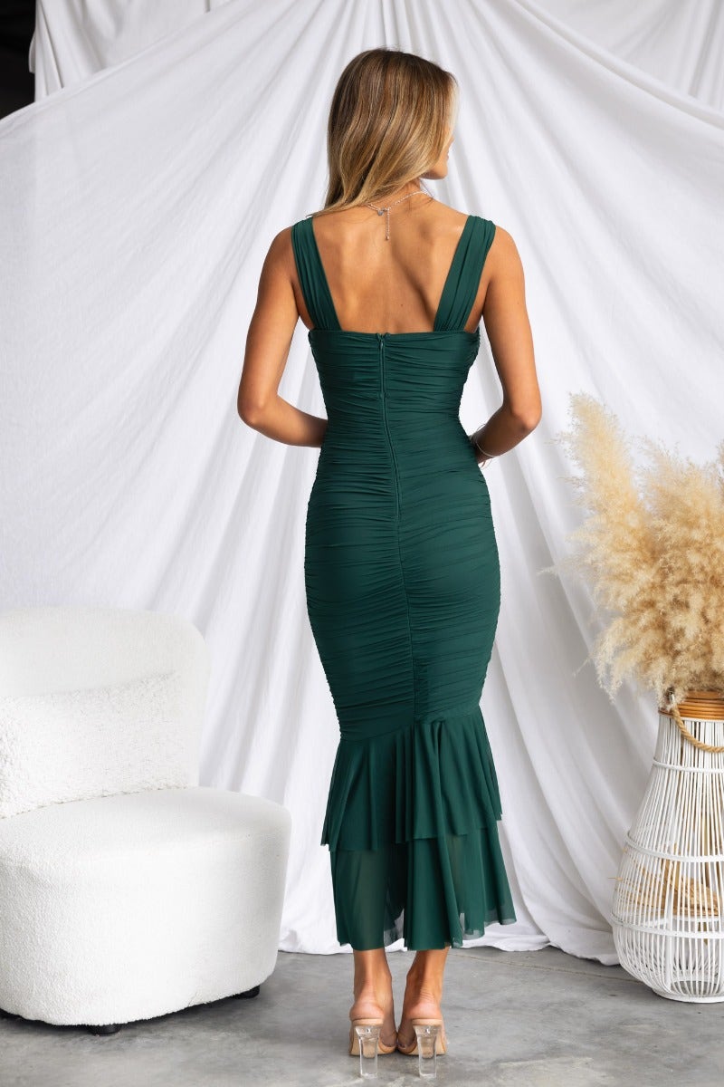 Model wearing a green Rosetta maxi dress with ruched design and ruffle hem, showcasing the back view.