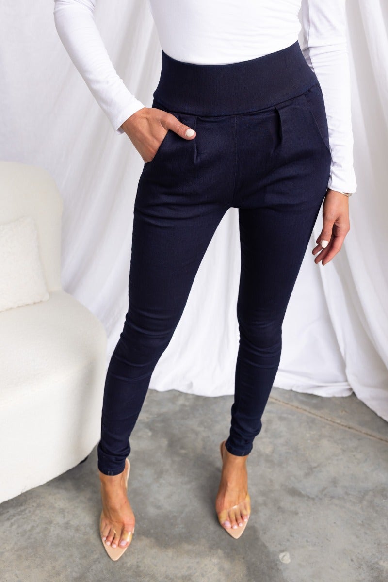 Navy high-waisted pants with pockets, smooth stretch material, shown on model, perfect for a stylish casual look.