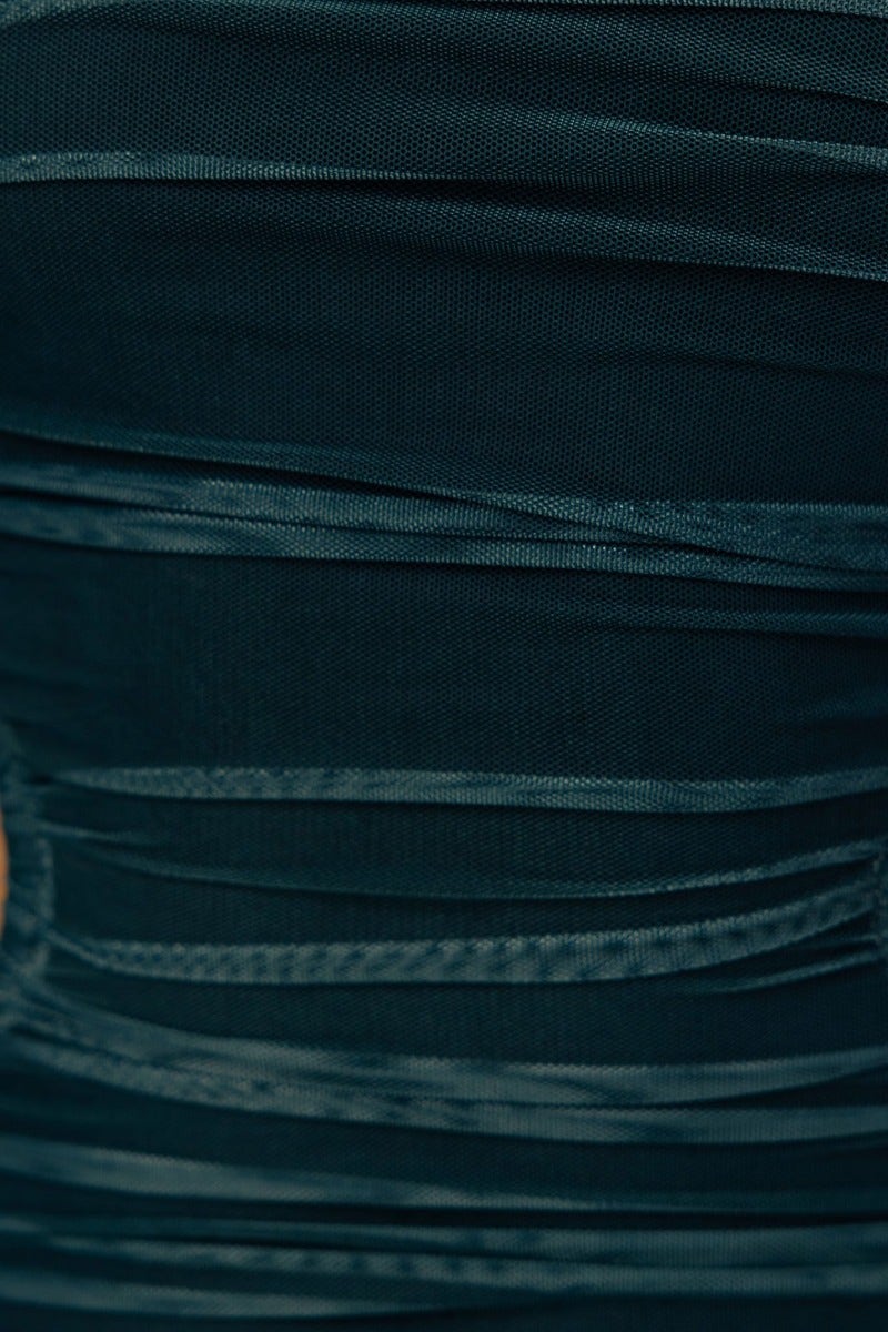Close-up of the ruched fabric detail on the Heart On Fire Maxi Dress, featuring a mesh overlay in dark teal.