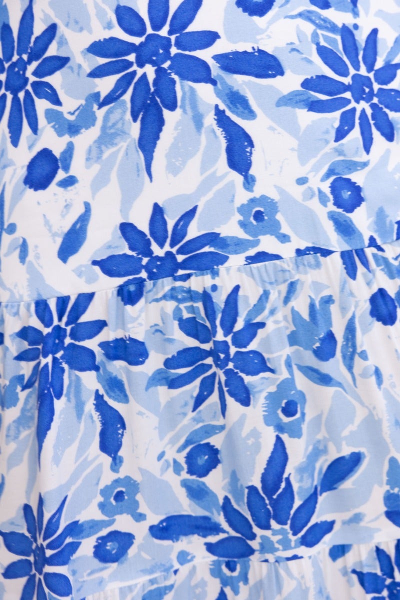 Abeila Maxi Dress featuring a blue floral print design on a white background, showcasing a vibrant pattern.