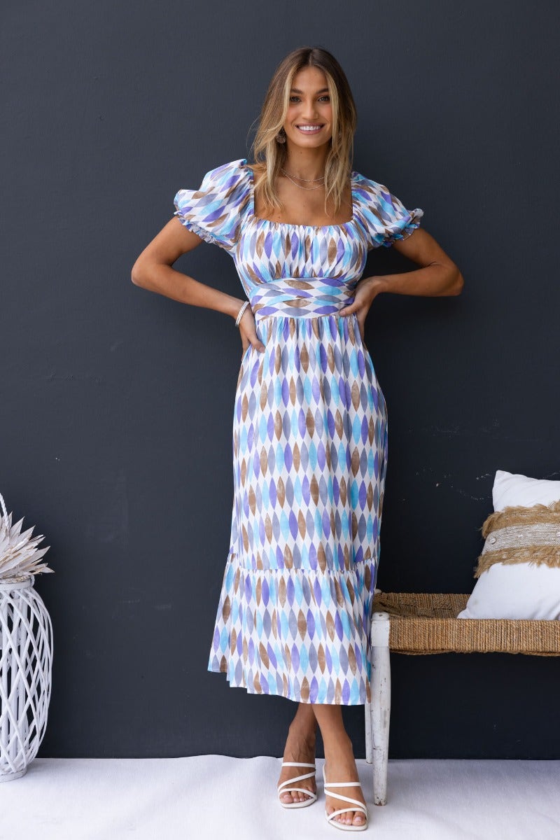Garland Midi Dress featuring a multi-color print, sweetheart neckline, and elastic sleeves, styled with pockets and a fabric tie.