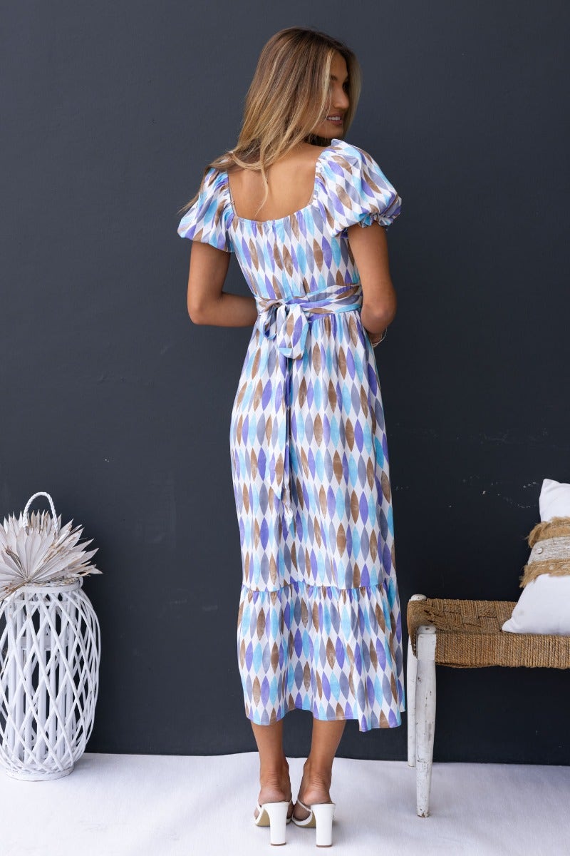 Model showcasing a multi-colour print midi dress with sweetheart neckline and attached fabric tie at the back.