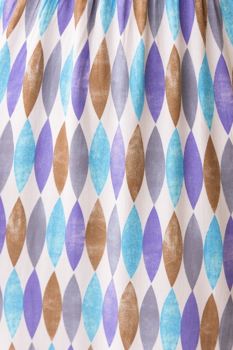 Close-up of multi-colour print fabric featuring blue, purple, and brown diamond patterns for Garland Midi Dress.