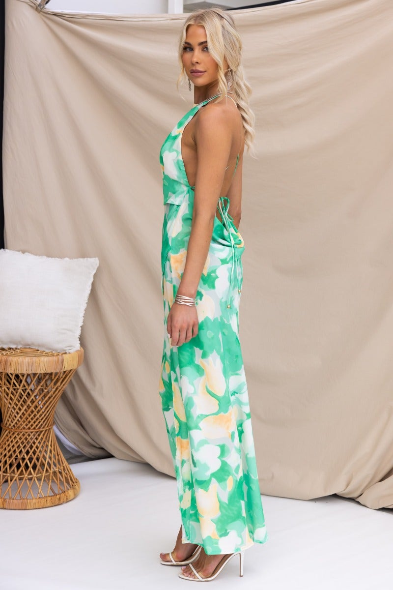 Model showcasing the Tangelo Maxi Dress with floral print, adjustable straps, and asymmetrical hemline.