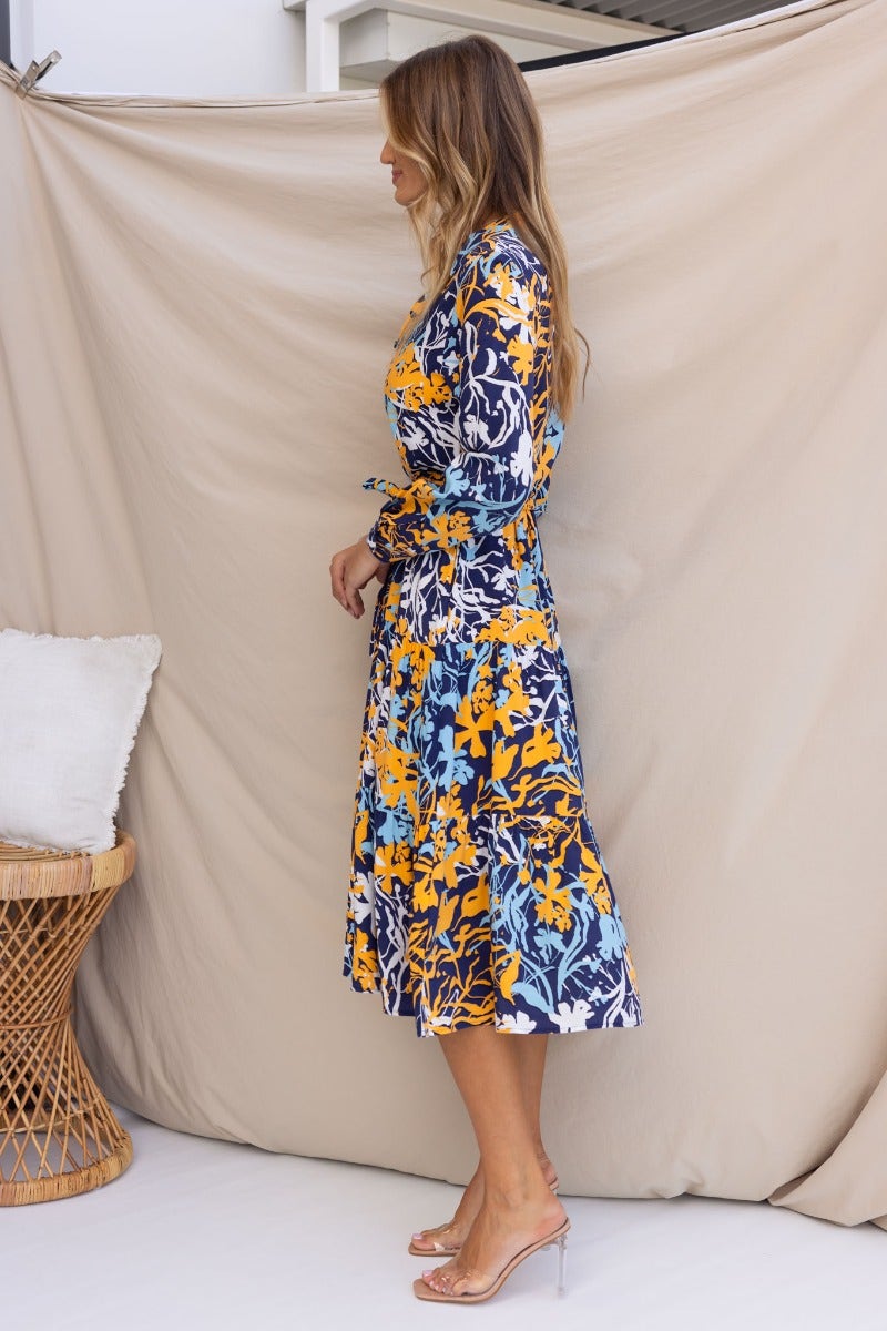 Side view of Chandra Midi Dress featuring navy floral print, collar, button-up front, and removable tie.