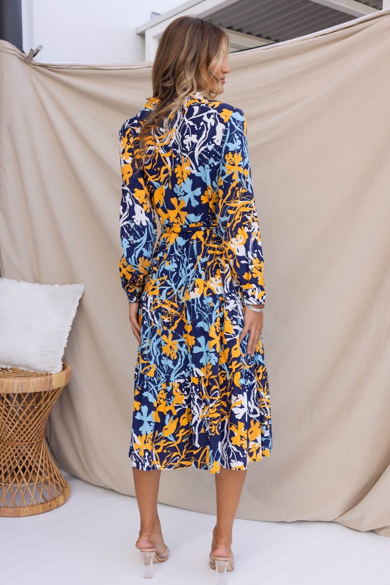 Navy floral midi dress with collar and button-up front, featuring a removable tie and pockets, shown from the back.