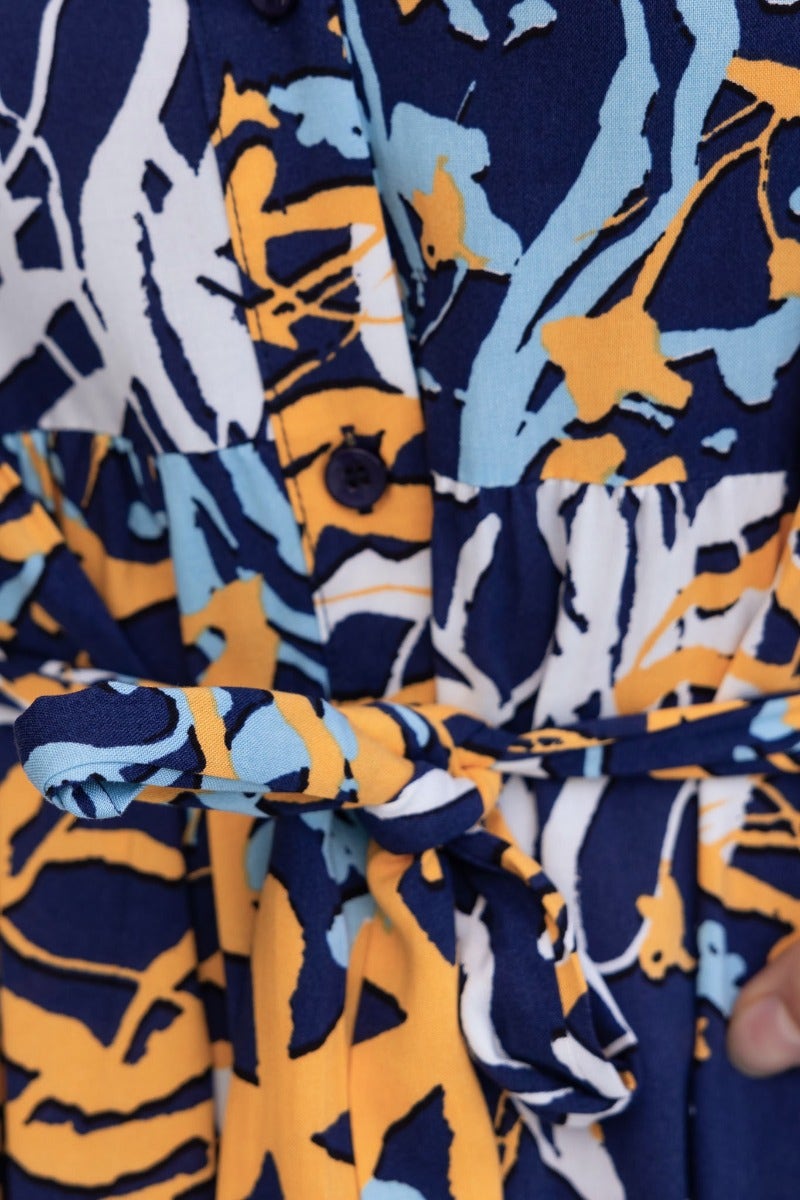 Close-up of Chandra Midi Dress showing navy print, collar, button-up front, and removable fabric tie.