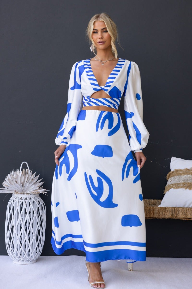 Qasim Maxi Dress featuring a satin fabric with blue patterns, twist detail at bust, and cut-out waist design.