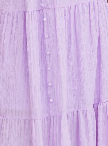 Close-up of Nammos Maxi Dress in textured lilac fabric featuring faux button-up front and tiered design.